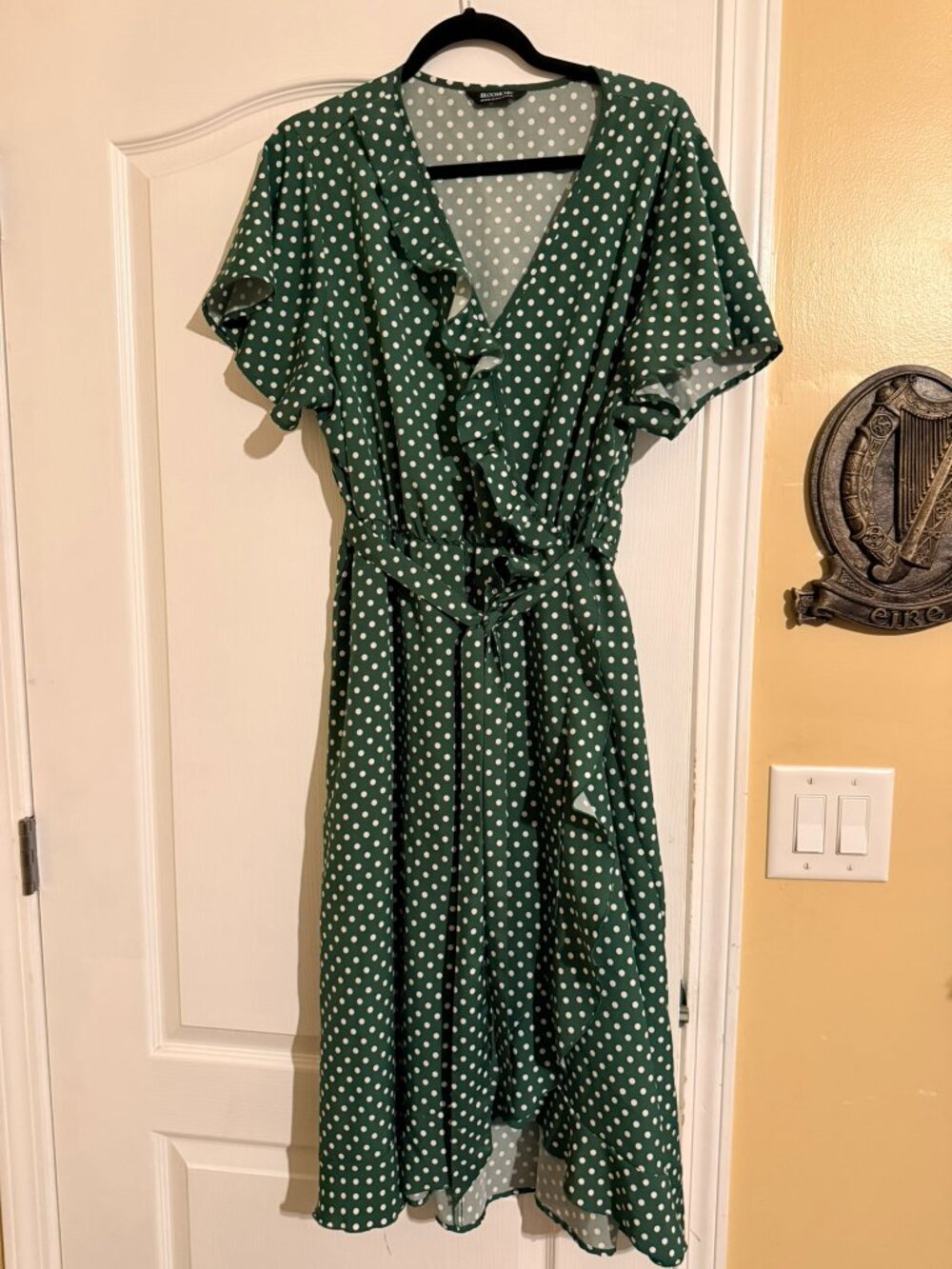 Cute green and white polka dot faux wrap dress with ruffles and tie belt